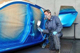 Profesional car painting in a paint booth.